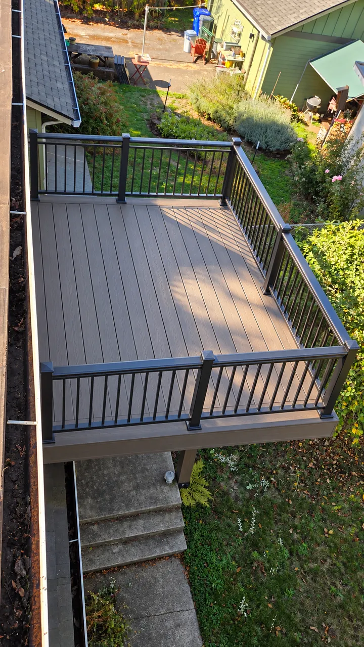 After: old wood deck replaced with composite decking and black metal railings