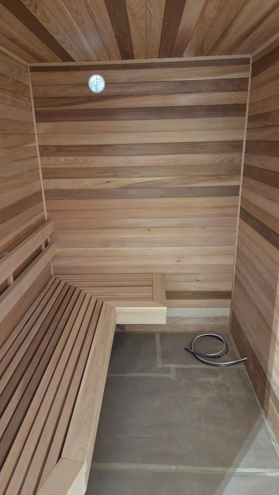 Cedar-lined sauna with L-shaped slatted bench