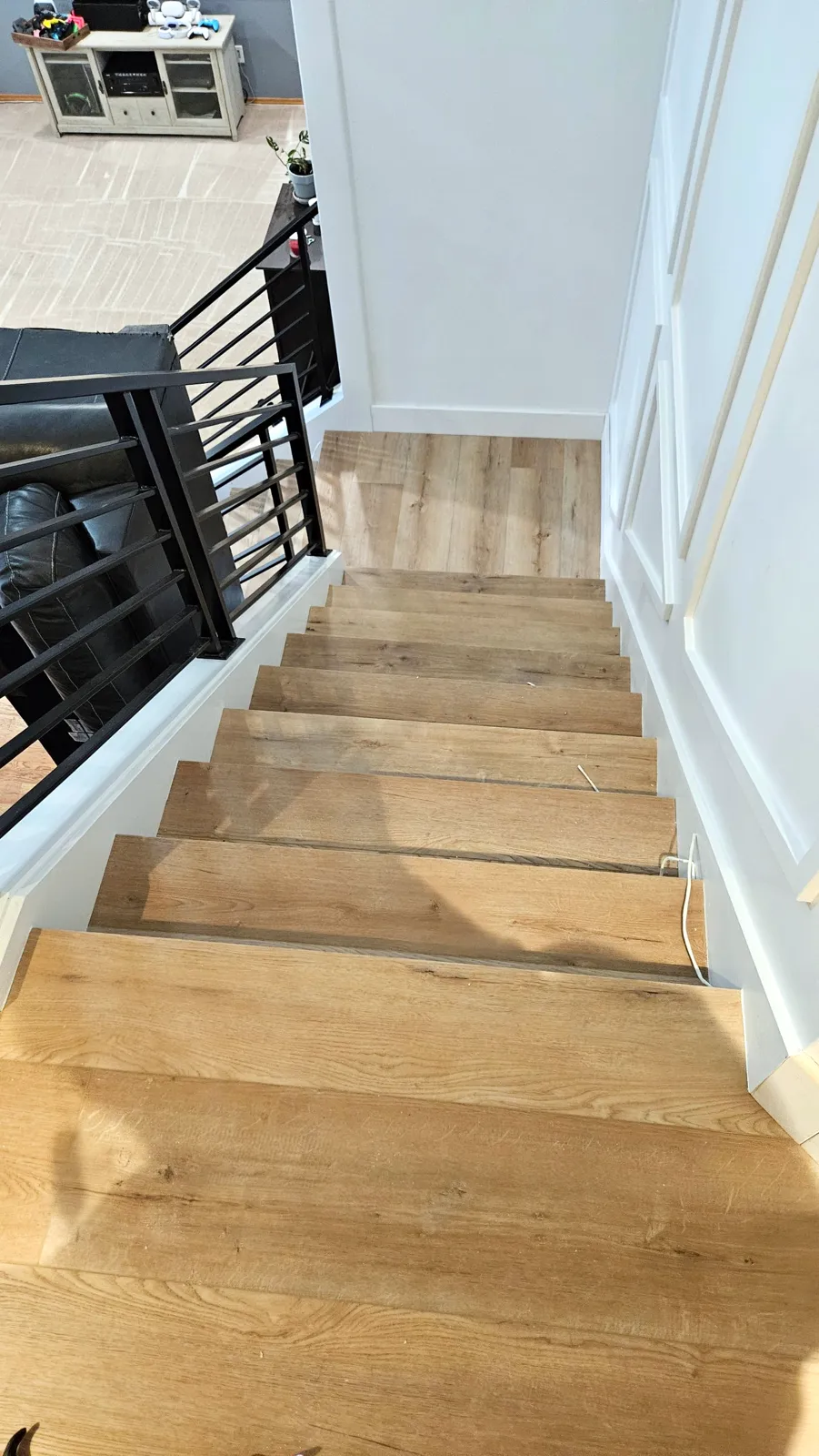 Light oak vinyl plank stairs with black metal railing